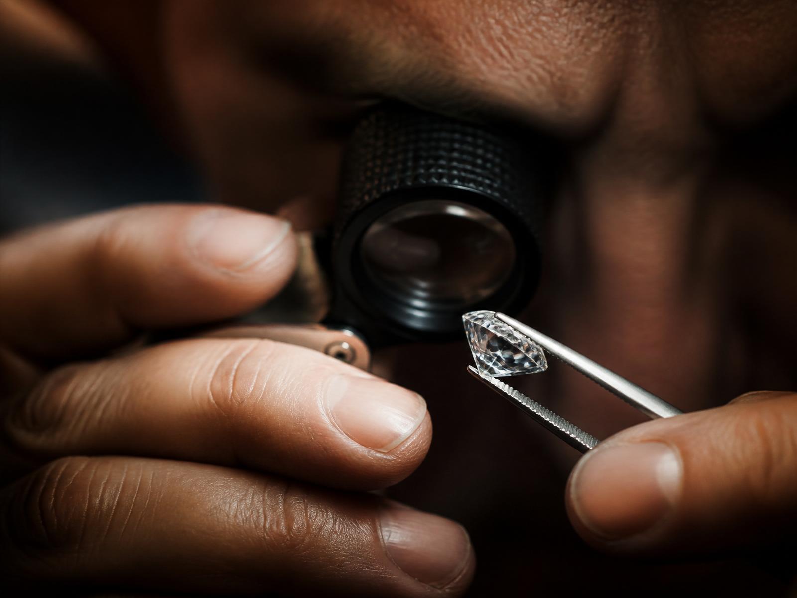 A jeweller inspecting a diamond with a loupe